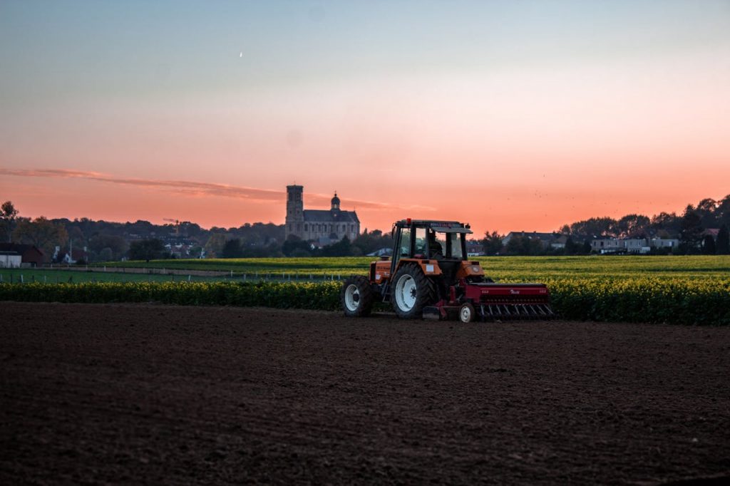 Farmers' mental health. Photo of a tractor ploughing a field by Nicolas Veithen